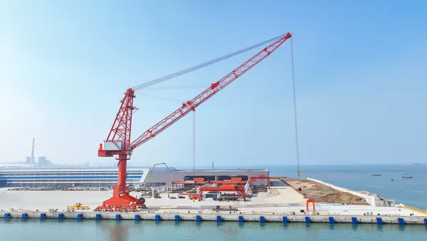 Crane portal di dermaga baru dengan pelabuhan dan bangunan galangan di belakangnya